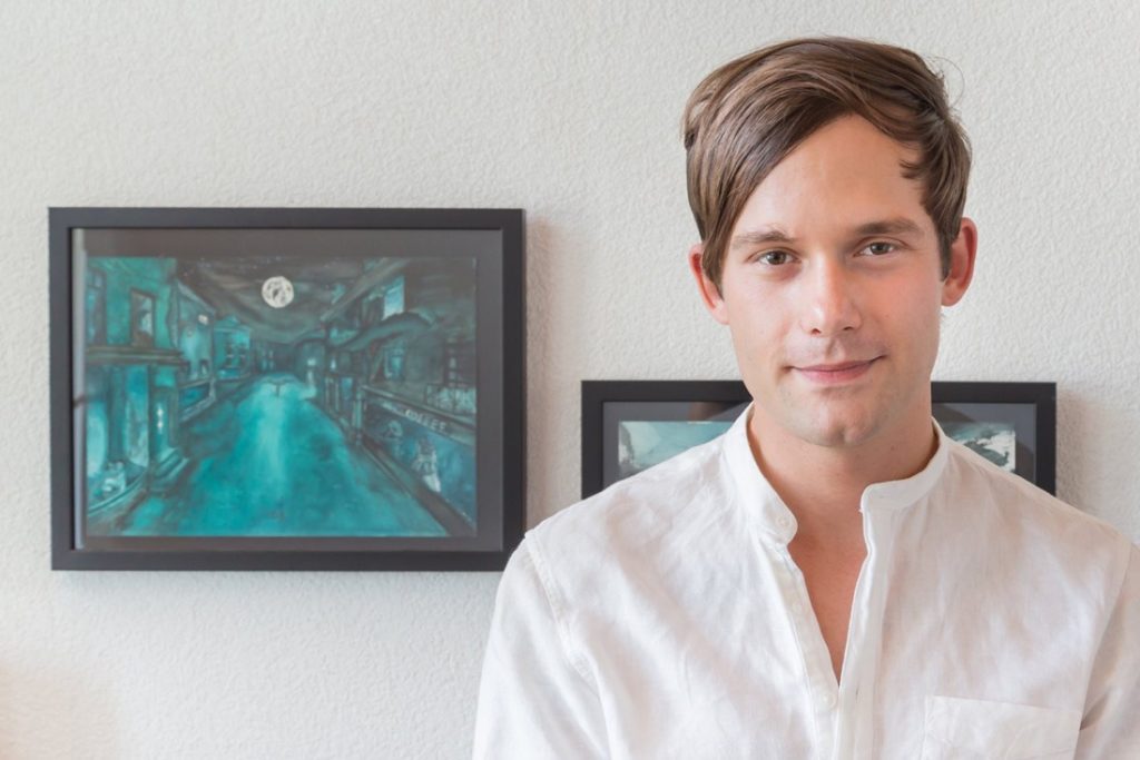 Portrait de Dylan Hermann devant ses aquarelles